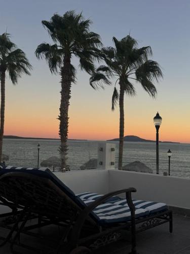 a view of the ocean and palm trees at sunset at BAJA MÍA in Loreto