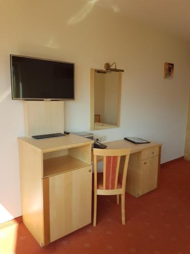 a desk with a monitor and a desk with a chair at Hotel Garni Alpendiamant in Fiss