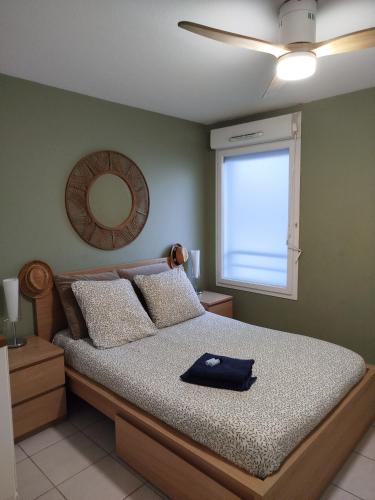 ein Schlafzimmer mit einem Bett, einem Spiegel und einem Fenster in der Unterkunft Le Vallon in Marseille