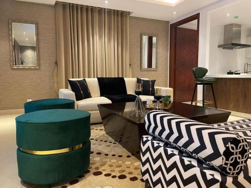 a living room with a couch and a table at GoldCrest Mall Luxury Apartments with Balcony In DHA Lahore in Lahore