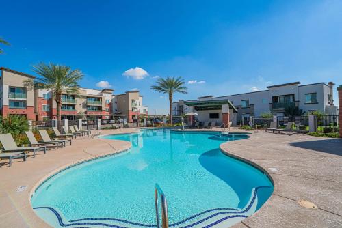 een zwembad in een resort met stoelen en gebouwen bij Live by Stadium with BalconyPoolGymParkingWD in Shamrock Mobile Home Park