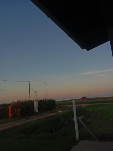 a view of a road with a fence and a field at Departamento santa elena in Frente Mar