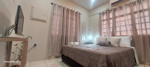 Un dormitorio con una cama y una ventana grande. en Scott Bushe City Studio, Wi-Fi, coffee, views, en Puerto España