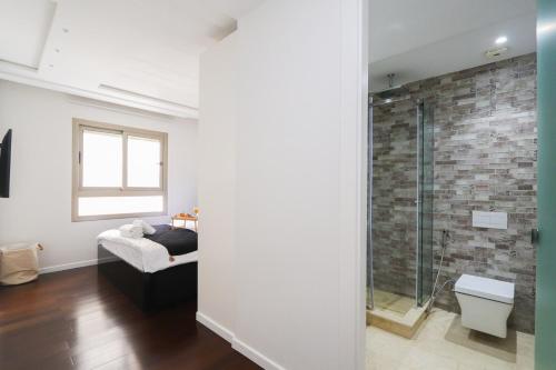 a bathroom with a glass shower with a brick wall at Luxury Sea View À 2 pas de la Marina in Tangier