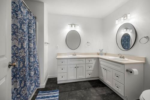 a bathroom with two sinks and two mirrors at SilverStrike Condos Family Friendly Walkable Location Unit 2 in Kellogg