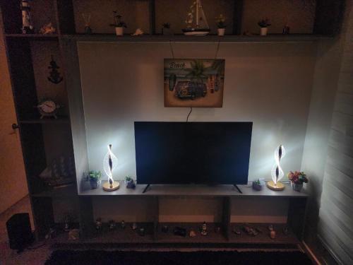 Una televisión o centro de entretenimiento en Departamento 2D y 2B Familiar