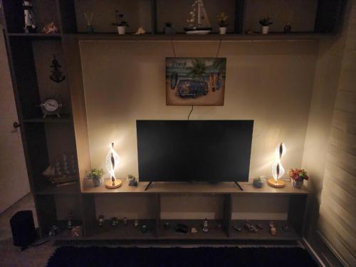 Una televisión o centro de entretenimiento en Departamento 2D y 2B Familiar