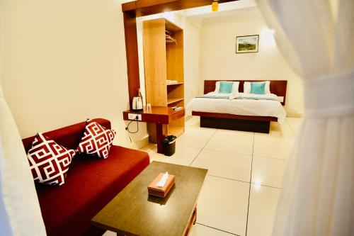 a bedroom with a bed and a red couch at GVK Holiday Inn in Mysore