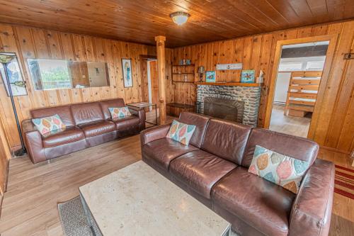 Arnold Beach House في روكواي بيتش: غرفة معيشة مع أريكة جلدية ومدفأة