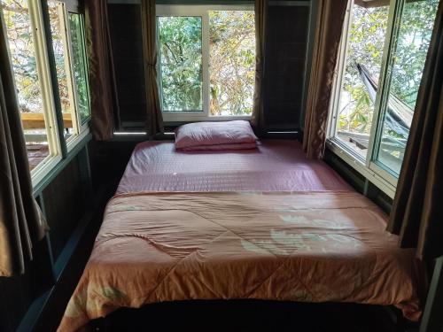 1 dormitorio pequeño con 2 camas y 2 ventanas en The Big House บ้านพักริมเล, en Ranong