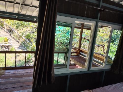 ventana en una habitación con vistas a un porche en The Big House บ้านพักริมเล, en Ranong