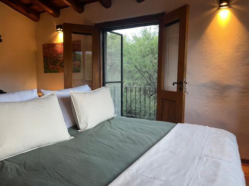 ein Schlafzimmer mit einem Bett mit weißen Kissen und einem Fenster in der Unterkunft Casa en La Comarca in San Javier