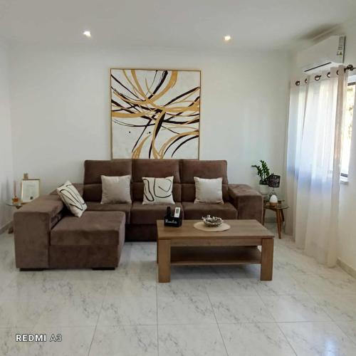 a living room with a brown couch and a coffee table at Diamond & Pearl in Olhão