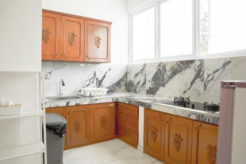 a kitchen with wooden cabinets and a sink at Casal Apartment by REJA Essentials in Nusa Dua