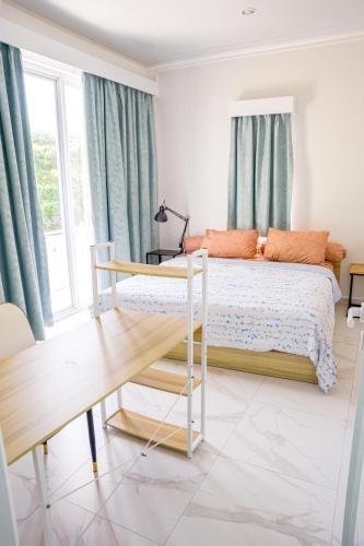 a bedroom with a bed with blue curtains at Casal Apartment by REJA Essentials in Nusa Dua