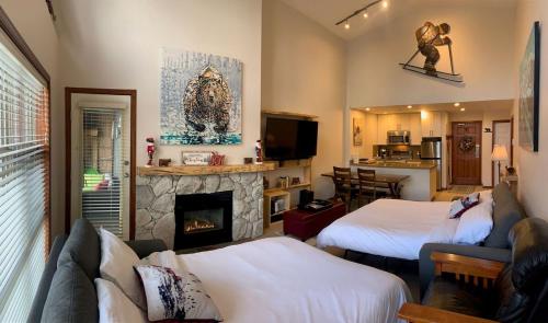 a living room with two beds and a fireplace at XL Luxury Penthouse Ski-in Ski-out The Aspens in Whistler