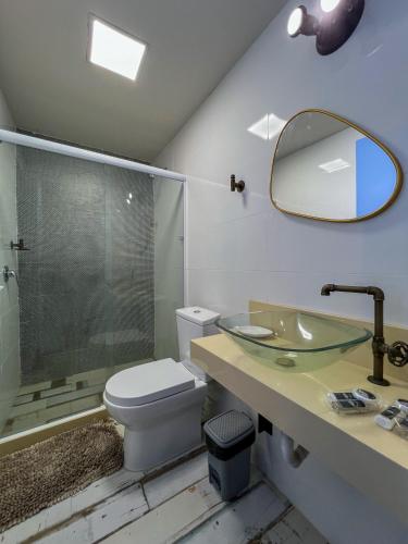 a bathroom with a toilet and a sink and a mirror at Refúgio Serra das Águas in Araras Petropolis