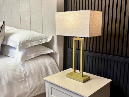 eine Lampe auf einem Tisch neben einem Bett in der Unterkunft Canterbury's Best Kept Secret! Unforgettable Home! in Canterbury