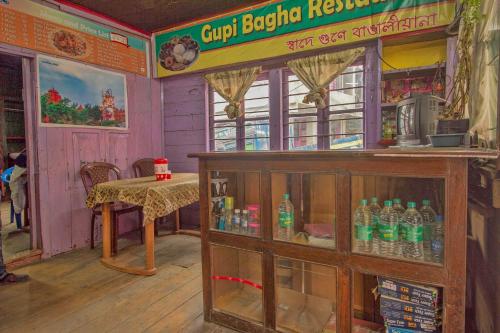a restaurant with a table and a lot of soda bottles at Hotel O Greenwood in Rishop