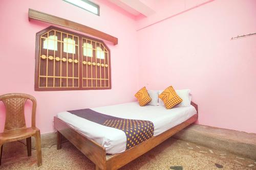 a bedroom with a bed and a chair and a window at Hotel O Greenwood in Rishop