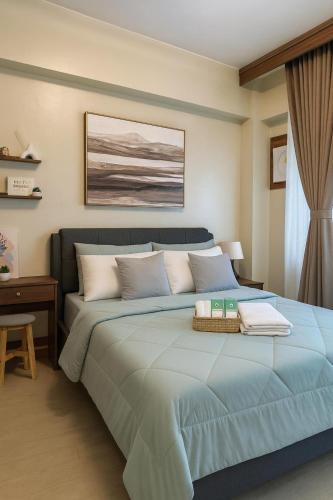 a bedroom with a blue bed and a window at Two Regis Bacolod Cozy 1BR Condo with Balcony in Bacolod