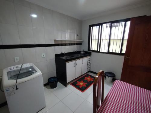 a kitchen with a sink and a table with a red table at Lar das Montanhas - 3 quartos até 8 pessoas in Marechal Floriano