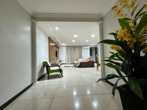 a living room with a couch and a vase of flowers at Lar das Montanhas - 3 quartos até 8 pessoas in Marechal Floriano