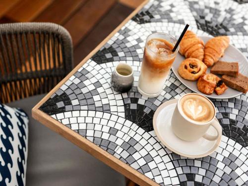 Una mesa con un plato de comida y una taza de café. en Tribe Bali Kuta Beach, en Kuta