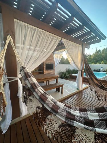 eine Hängematte auf der Terrasse eines Hauses in der Unterkunft Pousada Aloha Pinheira in Palhoça