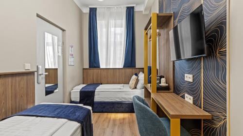 Una habitación de hotel con dos camas y un televisor. en Central Vienna Stay I Self Check-in near Nestroyplatz I Toilet on Hallway, en Viena