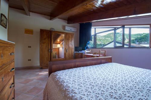 ein Schlafzimmer mit einem Bett und einem großen Fenster in der Unterkunft B&B Fasolino in Castellabate