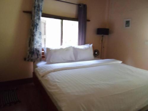 a bedroom with a white bed with a window at เฌอPrime Cher Prime by Tree house Maelai in Ban Pok Nai