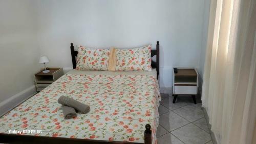 een slaapkamer met een bed en twee nachtkastjes bij Hostel Pé na praia - Quartos e Barracas Camping in Caraguatatuba