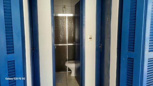 een badkamer met een toilet in een blauwe stal bij Hostel Pé na praia - Quartos e Barracas Camping in Caraguatatuba