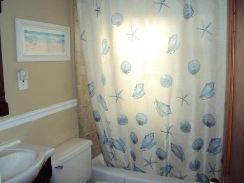 Ocean Side Home In Brant Beach 36525 في Brant Beach: حمام مع ستارة دش مع قشور عليه