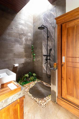 a bathroom with a shower and a sink at Umah Geina Ubud in Tegalalang