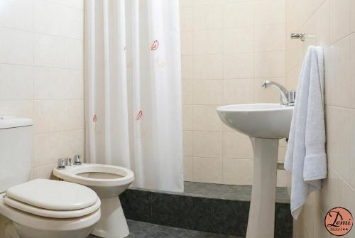 un baño con inodoro y lavabo en Hotel Demi, en Villa Gesell