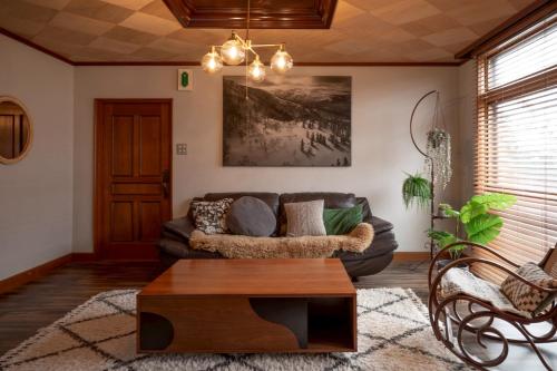 a living room with a couch and a coffee table at NIKI HOUSE -Yoichi 貸切一軒家 in Kurokawamachi