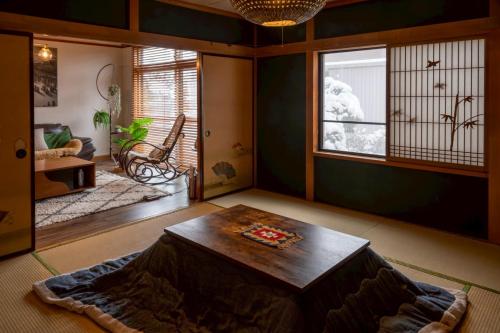 uma sala de estar com uma mesa e uma janela em NIKI HOUSE -Yoichi 貸切一軒家 em Kurokawamachi