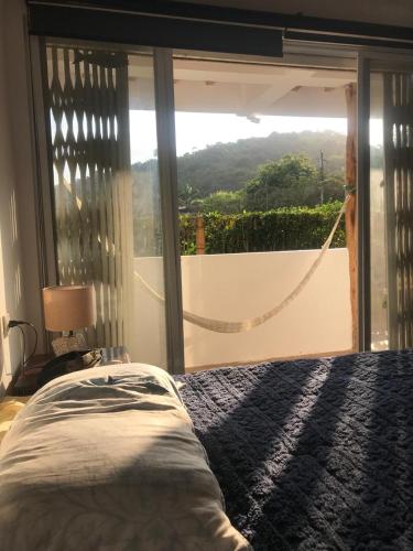 a bedroom with a bed and a view of a balcony at Ayampe Sunrise in Ayampe
