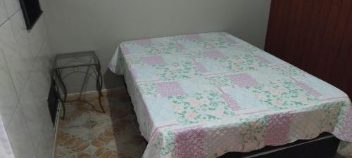 un letto con una trapunta in una stanza di Vista mar 1 a Imbituba