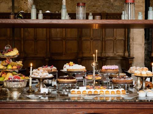 Un buffet de pasteles y tartas en una mesa. en Abbaye Des Vaux De Cernay, en Cernay-la-Ville