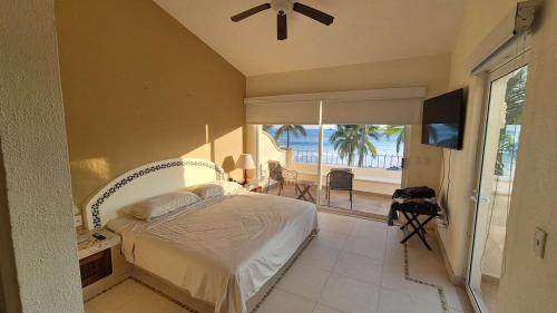 a bedroom with a bed and a view of the ocean at Luxury Beachfront Condo at Iguana-Ixtapa in Ixtapa
