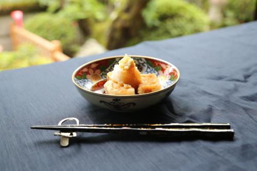 a bowl of food on a table next to a pair of keys at 岸之坊 Kishinobo Temple inn in Minobu