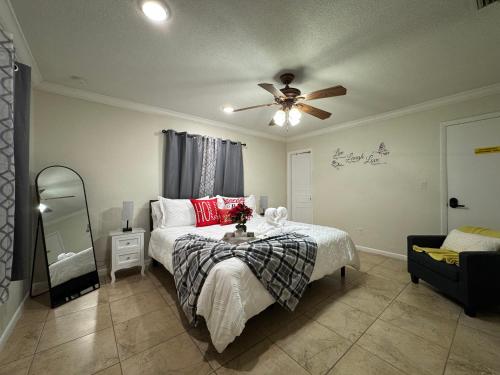 Un dormitorio con una cama y un ventilador de techo. en Sunshine Nest, en Lehigh Acres
