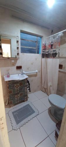 a bathroom with a toilet and a sink at Casa familiar ampla in São Gabriel