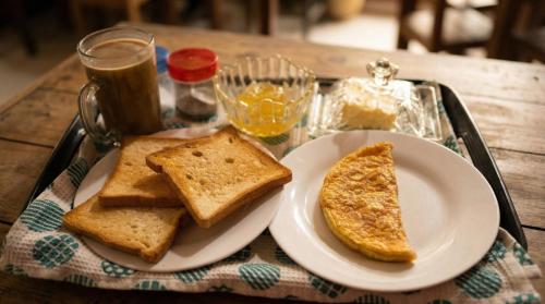 a tray with bread and toast on a table at Surfing Beach Guest House in Hikkaduwa