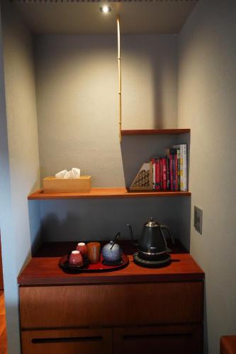 a kitchen with a desk with tea pots and books at 岸之坊 Kishinobo Temple inn in Minobu