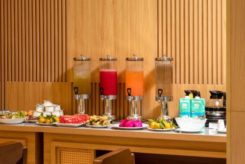 a buffet with plates of fruit and drinks on a table at Cat Ba Wistaria Hotel- Jacuzzi Rooftop & Fitness in Cat Ba
