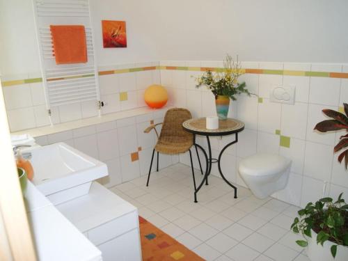 een badkamer met een tafel, een toilet en een wastafel bij Pension Espenhof in Strüth